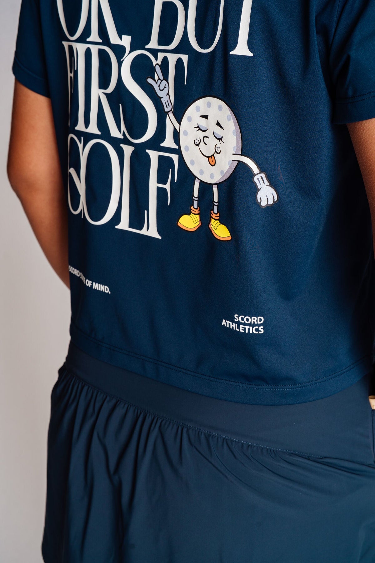 The Scord OK But First Golf graphic tee, a women's golf t-shirt — back view